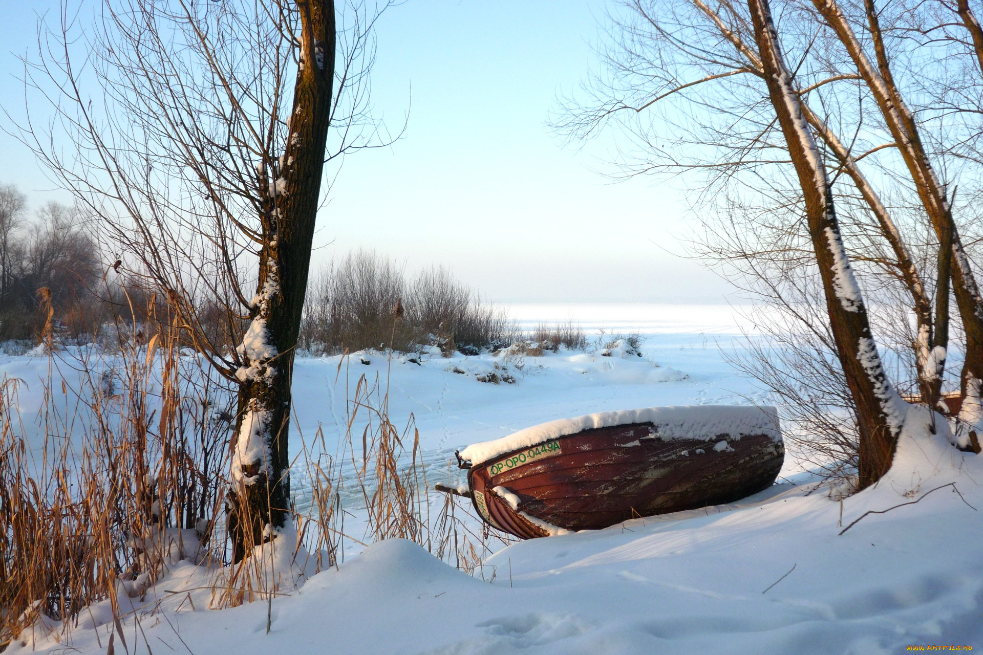 Берег озера зимой. Лодка зимой. Лодка в снегу. Озеро зимой. Снег река лодка.